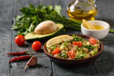 Solmayan çiçek tohumları ile vejetaryen salata, siyah ahşap bir masa üzerinde avokado ve kiraz domates. Diyet vejetaryen tabağı.