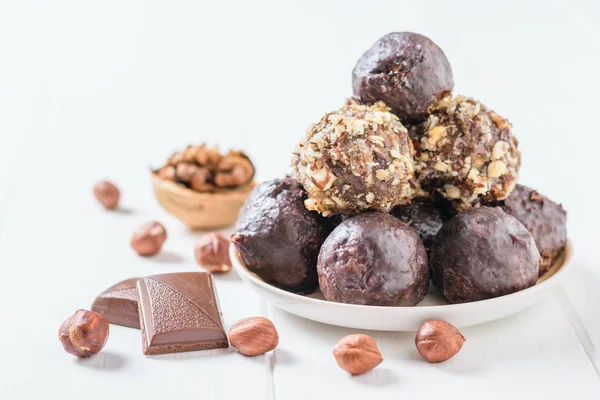 Ev yapımı tatlılar fındık, Kuru meyve, çikolata yaptı ve beyaz bir tablo ve ceviz bir tabakta bal. Lezzetli taze ev yapımı şekerlemeler.