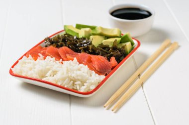 Soya sosu ve salata avokado, pirinç, deniz yosunu ve balık beyaz masada ile top. Akdeniz diyeti mutfağı