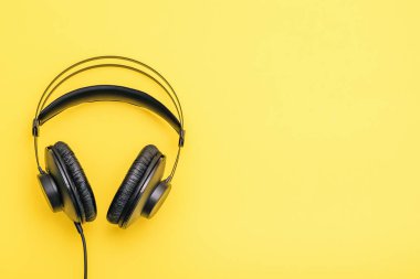Teller sarı bir arka plan üzerinde siyah kulaklıklarla. Müzik ve iletişim için dinlemek için aksesuar.