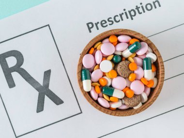 Doktor reçete ve hap mavi bir tablo ile ahşap bir kase ile bir levha. Üstten görünüm. Tedavi ve hastalıkların önlenmesi kavramını. Düz yatıyordu.
