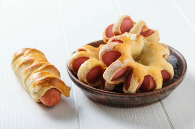 Taze ev yapımı sosis ilginç bir hamur beyaz ahşap bir masa üzerinde bir kil kase şeklinde hazırlanmış. Hamur ve sosis yapılmış lezzetli et snack.