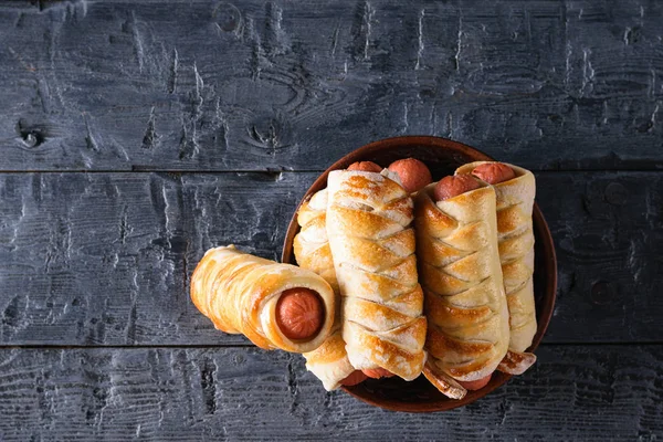 Taze pişmiş ev yapımı sosis koyu ahşap bir masa üzerinde bir kil kase alır. Lezzetli et Aperatif hamur ve sosis yaptı. En iyi düz görünümünden yatıyordu.