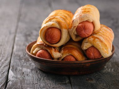 Beş taze, ev yapımı domuz sosisli siyah ahşap masa üzerinde. Hamur ve sosis yapılmış lezzetli et snack.