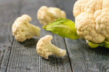 Yapraklarda siyah ahşap bir masa ile karnabahar. Sağlıklı vejetaryen diyet.