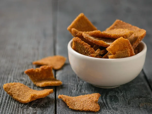 Pieces of dried bread in a white bowl on a black wooden table. Appetizer of dry bread with spices. — Stock Image Pieces Dried Bread White Bowl Black Wooden Table Appetizer Dry Stock Image