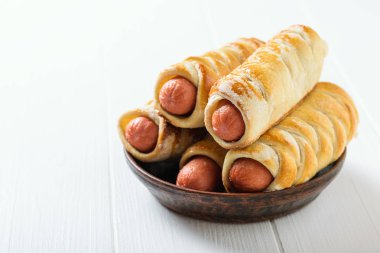 Taze hazırlanmış domashnii sosis ile dolu bir kil kase izolirovannye bir beyaz rustik tabloyu temel alır. Hamur ve sosis yapılmış lezzetli et snack.