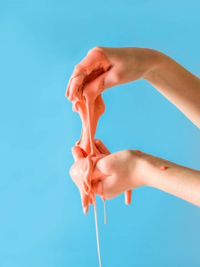 Çocuğun elinden turuncu bir gülümseme mavi bir arka plan üzerinde izler. Oyuncak antistress. El motor becerilerinin geliştirilmesi için oyuncak.