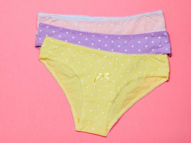 Üç kadın Pamuk külot üzerinde bir ışık arka plan pembe. Moda kavramı. Güzel iç çamaşırı.