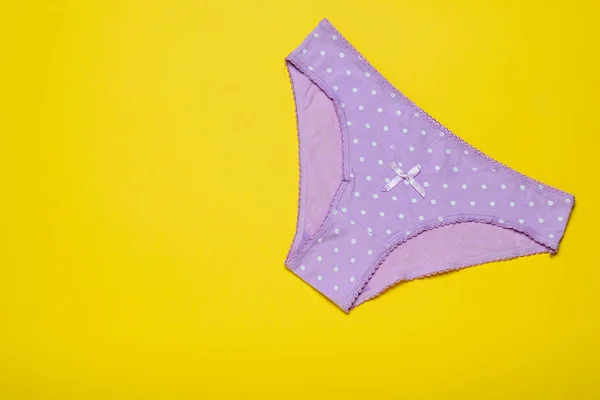 Bragas de mujer lila sobre un fondo amarillo brillante. Concepto de moda. Hermosa lencería. La vista desde arriba . — Foto de Stock