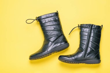 Kadın botları sarı bir arka plan üzerinde hakiki deri. Üstten Görünüm. Moda anlayışı.