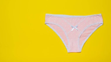 Kadın külot parlak sarı bir arka plan üzerinde pembe. Moda kavramı. Güzel iç çamaşırı. Üstten Görünüm.