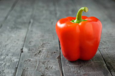 Güzel olgun kırmızı dolmalık biber siyah bir rustik ahşap tablo. Vejetaryen yiyecekler.