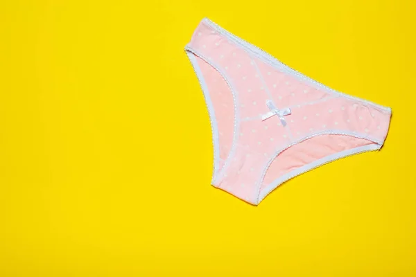 Pantalón de mujer rosa sobre un fondo amarillo claro brillante. Concepto de moda. Hermosa lencería. La vista desde arriba . —  Fotos de Stock