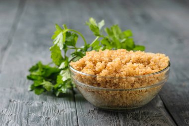 Cam kase haşlanmış quinoa tahıl Siyah ahşap bir masa üzerinde ile.