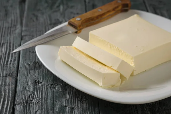 Cortar con un cuchillo trozo de queso serbio en una mesa de madera. La vista desde arriba. Productos lácteos . —  Fotos de Stock