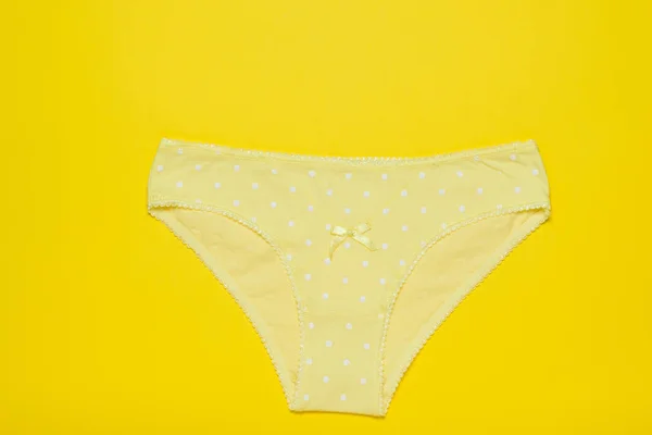 Yellow women's cotton panties on a bright yellow background. Fashionable concept. Beautiful lingerie. The view from the top. — Stock Photo, Image