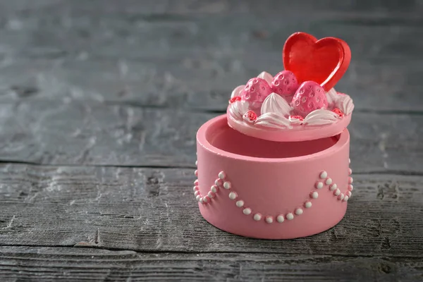 Decorado con abalorios y caja del corazón sobre una mesa de madera negra. Minimalista . — Foto de Stock