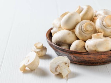 Dilimlenmiş mantar mantar beyaz bir tabloda bir kâse yanında. Vejetaryen mutfağı.