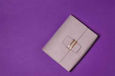 Hafif deri bayanlar çanta mor zemin üzerine. Modern kadın deri aksesuar. Üstten Görünüm.