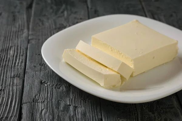 Plasterki sera serbski na płytce białe na białym, drewnianym stole. Widok z góry. Produkt Mleczny. — Zdjęcie stockowe