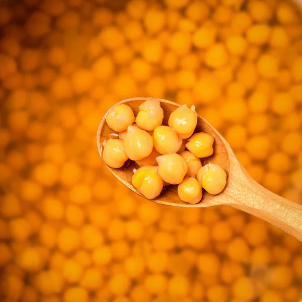 Fasulye kasesinin arka planında kaynamış nohut olan tahta kaşık. Yukarıdan görünüşü.