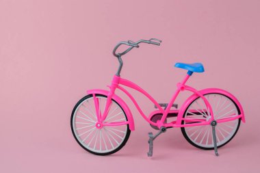 Pembe arka plan üzerinde mavi eyer ile kırmızı bisiklet.