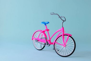 Açık mavi arka plan üzerinde mavi eyer ile kırmızı bisiklet.