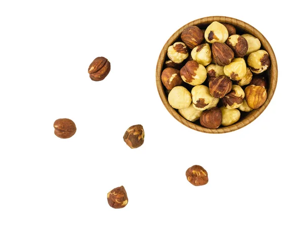 Wooden bowl with roasted hazelnuts and scattered nuts isolated on white background. Prepared with the harvest of hazelnuts. Flat lay. — Stock Photo, Image