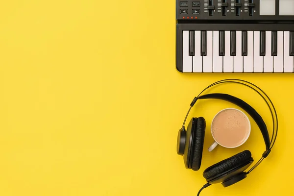 Misturador de música e fones de ouvido pretos e café no fundo amarelo. A vista de cima . — Fotografia de Stock