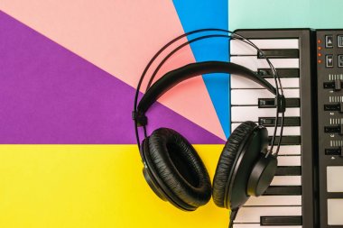 Siyah kulaklıklar ve çok renkli arka planda bir müzik karıştırıcı. Yukarıdan görünüm.