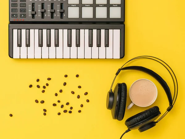 音楽ミキサー、散乱コーヒー豆、ヘッドフォン、黄色の背景にコーヒーカップ。上からの眺め. — ストック写真