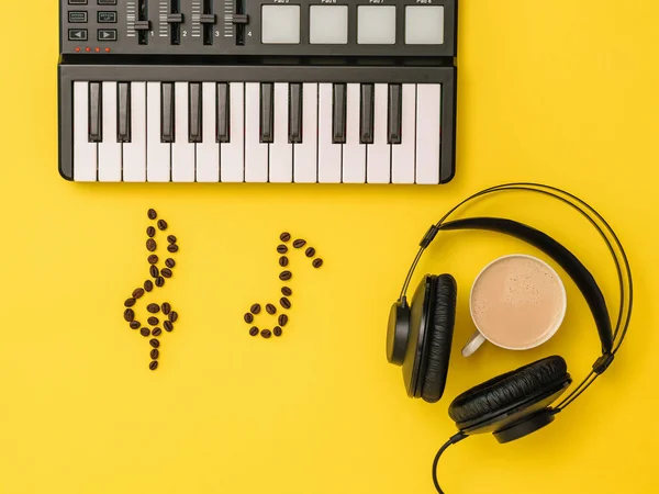 노란색 배경에 음악 믹서, 커피 콩 노트와 헤드폰. 음악을 쓰는 개념. 위에서 보는 경치. — 스톡 사진
