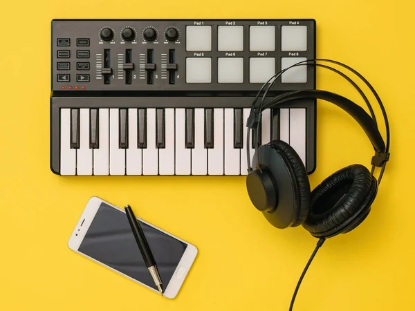 黄色背景的音乐混音器、智能手机、耳机和笔。工作场所组织的概念. — 图库照片