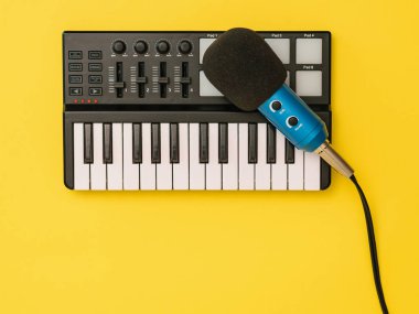 Sarı arka plandaki müzik mikseri için mikrofon. İşyeri organizasyonu kavramı.