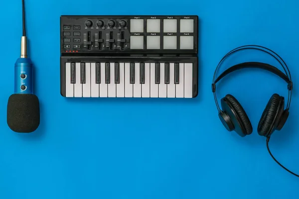 Muziek mixer, microfoon en hoofdtelefoon op blauwe achtergrond. Het concept van de organisatie van de werkplek. — Stockfoto