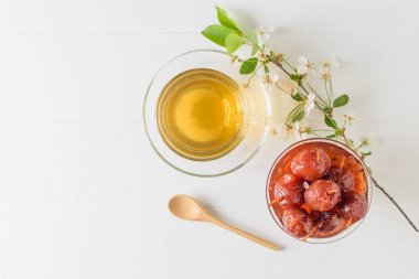 Beyaz ahşap bir masada çiçek açan dal, çay ve Elma reçeli. Yukarıdan manzara. Düz yatıyordu.