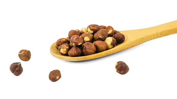 Roasted hazelnuts and wooden spoon isolated on white background. — Stock Photo, Image