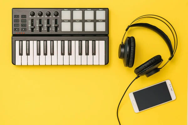Smartphone, mixeur de musique et écouteurs sur fond jaune vif. Le concept d'organisation du lieu de travail . — Photo