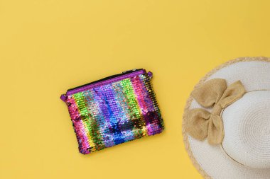 Kadınlar için yaz şapkası ve parlak sarı arka plan üzerinde renkli çanta. Yaz tatili kavramı. Düz yatıyordu.