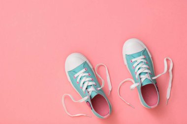 Pembe bir arka planda dantel olan bir çift turkuaz ayakkabı. Renk eğilimi 2019. Spor tarzı. Düz yatma.