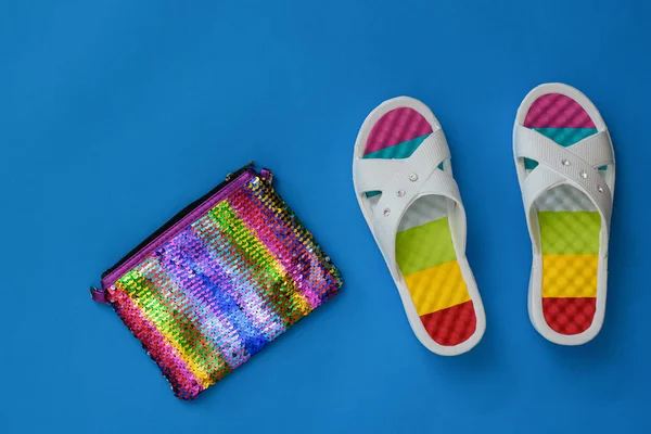 Hermosos zapatos de playa y bolso colorido sobre fondo de papel azul. El concepto de vacaciones de verano. Puesta plana . — Foto de Stock