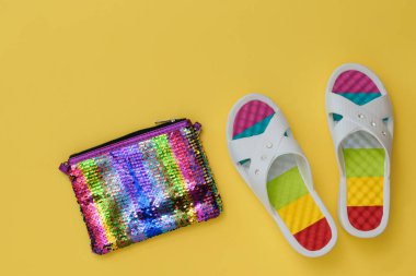 Güzel plaj ayakkabıları ve sarı kağıt arka plan üzerinde renkli çanta. Yaz tatili kavramı. Düz yatıyordu.