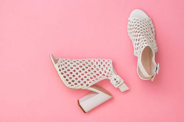 Pembe arka plan üzerinde güzel moda kadın yaz ayakkabıları. Düz yatıyordu.