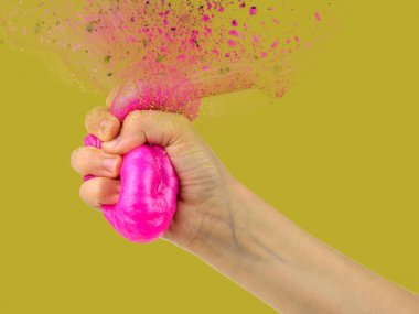 Slime explodes in his hand on a yellow background. A collage of hands of the child and the toy. clipart