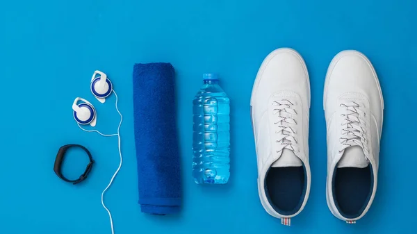 Fitness accessories blue background. Sports style. Flat lay.