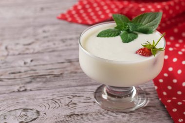 Kırmızı kumaş bir arka plan üzerinde ahşap bir masa üzerinde yoğurt Kase.