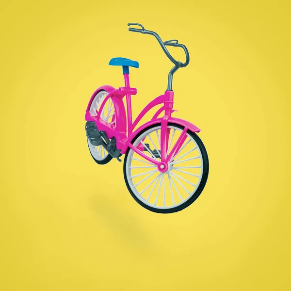 Brinquedo bicicleta vermelha com uma sela azul em um fundo amarelo . — Fotografia de Stock