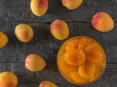 Masa kayısı ve ahşap bir masa üzerinde reçel bir kase üzerine dağınık.