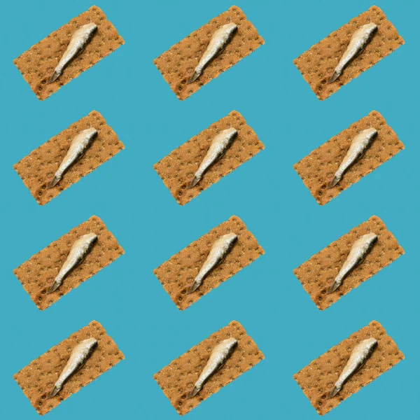 Sfondo di pesce affumicato su un pezzo di pane tostato su sfondo blu. Collage d'arte . — Foto Stock